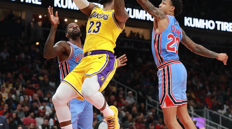 Hawks forward John Collins blocks a shot by the  Lakers’ LeBron James during the second half of a Feb. 12 game in Atlanta.