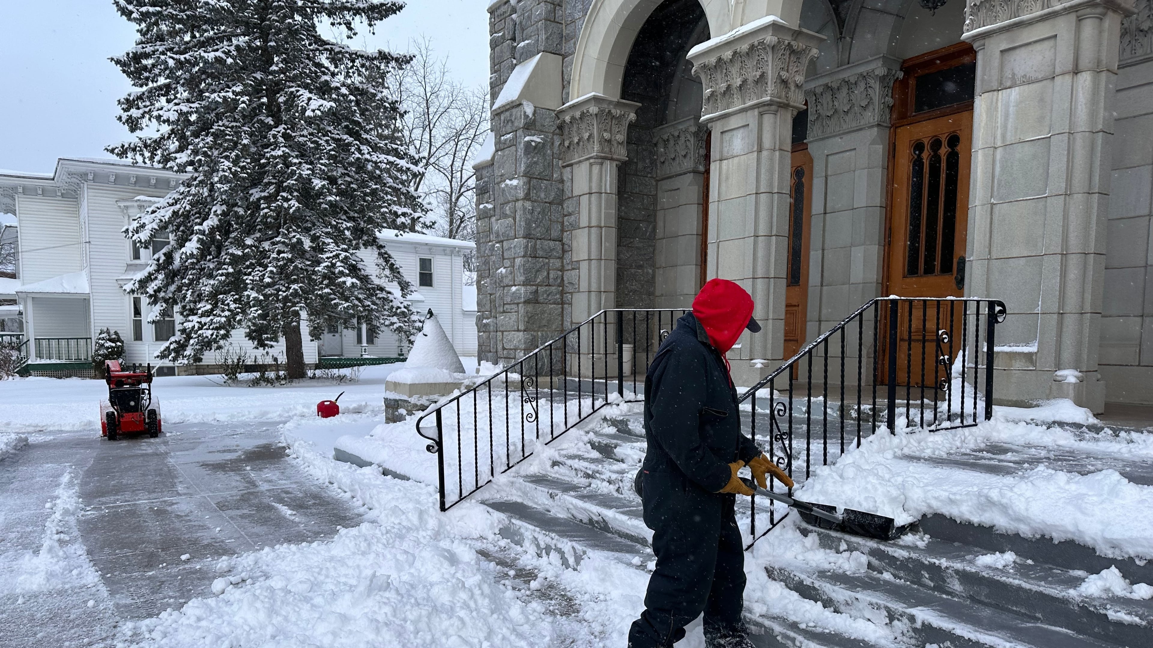 A man shovels snow outside a church in Lowville, N.Y., on Friday, Nov. 28, 2025. (AP Photo/Cara Anna)