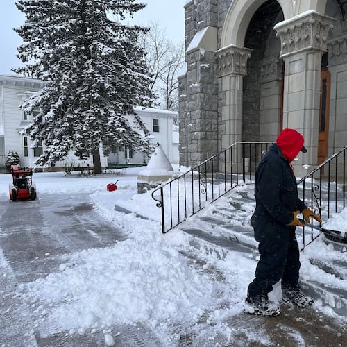 A man shovels snow outside a church in Lowville, N.Y., on Friday, Nov. 28, 2025. (AP Photo/Cara Anna)