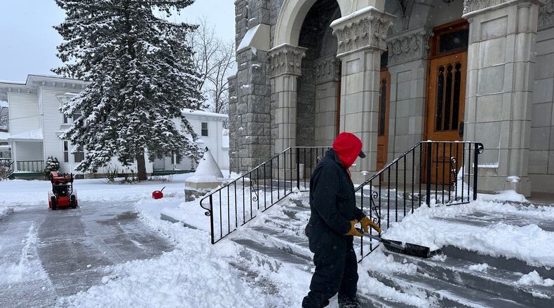 A man shovels snow outside a church in Lowville, N.Y., on Friday, Nov. 28, 2025. (AP Photo/Cara Anna)