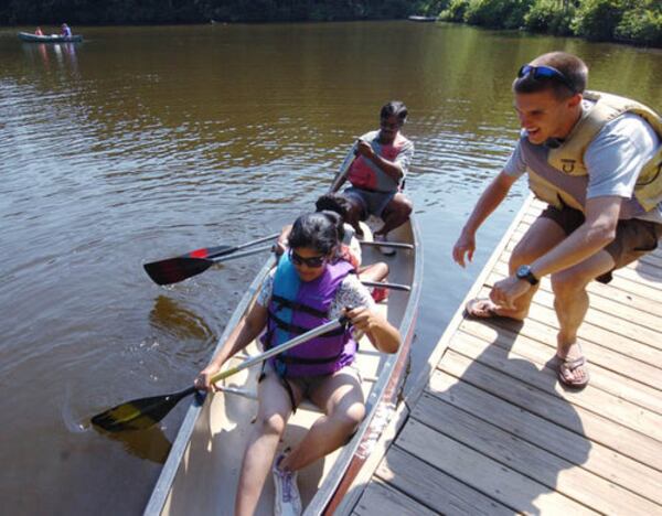 Instructor James Herrin, right, helps the Nemani family of Alpharetta cast off their canoe.