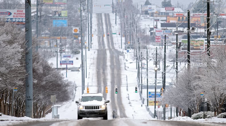 A lone SUV makes its way North on a slushy Metropolitan Parkway in Southwest Atlanta on Thursday morning February 13, 2014, as snow falls again over the Metro.