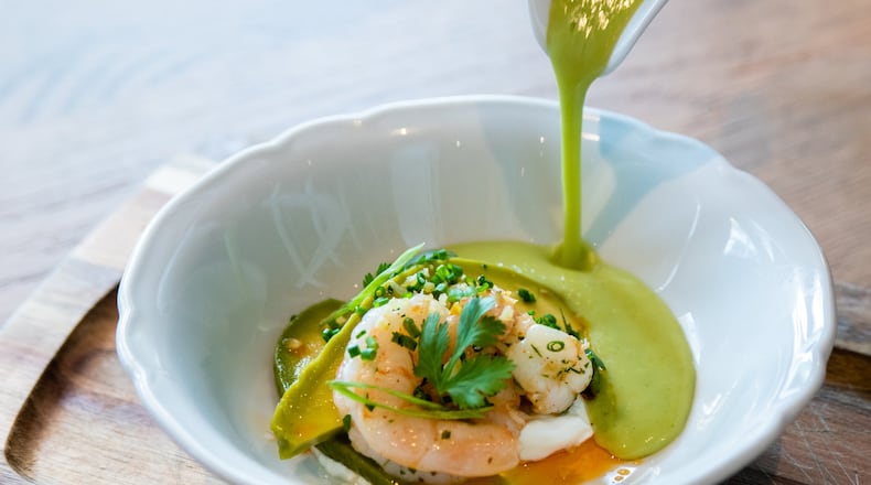 Gazpacho gets a Southern twist at Achie’s, where the traditional Spanish chilled soup is made with green tomatoes. The gazpacho, which comes with Georgia shrimp, pickled avocado, a dab of creme fraiche and a few drops of chile oil, is poured tableside. CONTRIBUTED BY HENRI HOLLIS