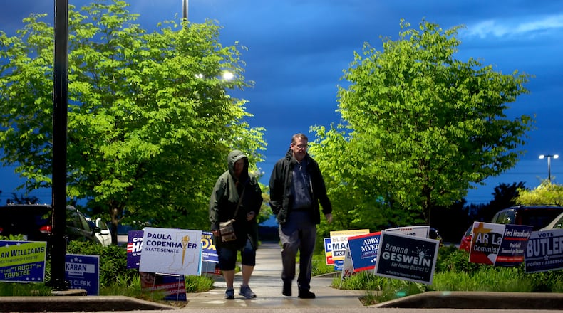 People walk through signs in a front of a vote center during a primary election on Tuesday, May 5, 2026, in West Lafayette, Ind. (AP Photo/Cara Penquite)
