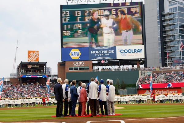 Billye Aaron and Hank Aaron's former teammates and Gov. Brian Kemp watch the Jumbotron during the 50th-anniversary celebration of Aaron’s 715th home run at Truist Park on Monday, April 8, 2024. (Miguel Martinez/AJC)