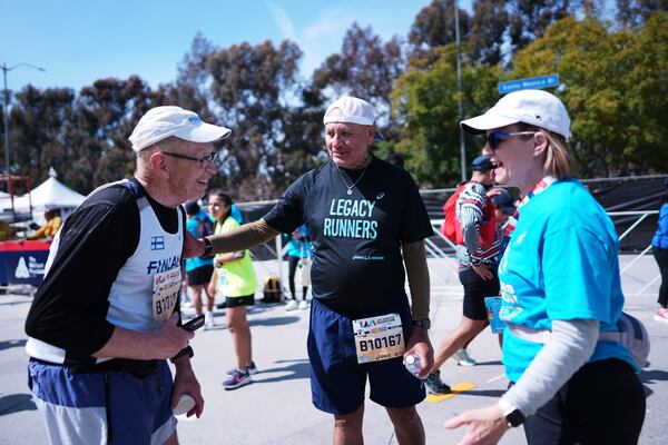 Lou Briones, center, talks to fellow runner Jussi Hamalainen, left, after they both finished the LA Marathon Sunday, March 16, 2025, in Los Angeles. (AP Photo/Eric Thayer)