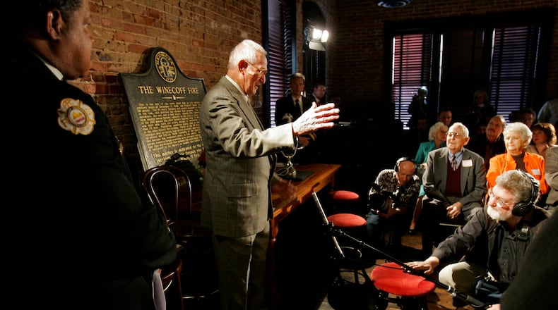 Rick Roberts speaks to people gathered at The Spotted Dog -- which used to house Fire Station 11 -- during a commemoration to mark the 60th anniversary of the Winecoff Hotel fire in downtown Atlanta. Roberts, a firefighter at the time who went on to become battalion chief, is credited with helping to save several of the survivors. The fire, at 119 deaths, the worst hotel fire in U.S. history, caused departments across the country to update their fire safety codes. (Allen Sullivan / Special)