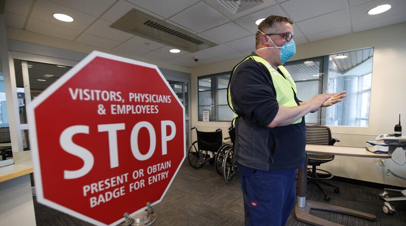 Bradley Mattes, associate nurse leader at Central Maine Medical Center, questions patients at the emergency entrance to the hospital in Lewiston, Maine, Friday, March 13, 2020. (AP Photo/Robert F. Bukaty)