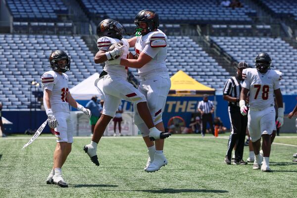 Hebron Christian running back JJ Stowers (4, left) celebrates his rushing touchdown with offensive lineman Cade Kivett (75) during the first half against Carver-Atlanta in a GHSA football game in the Corky Kell + Dave Hunter Classic at Georgia State’s Center Parc Stadium, Friday, August 21, 2026, in Atlanta. (Jason Getz/AJC)