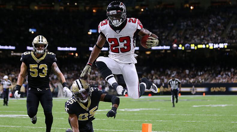 Falcons running back Brian Hill scores a touchdown as the Saints' Eli Apple and A.J. Klein trail during the second half Nov. 10, 2019, at the Mercedes Benz Superdome in New Orleans.