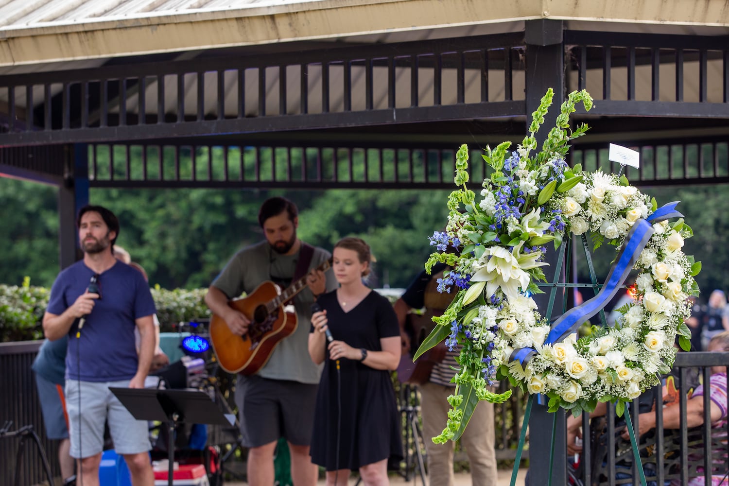 Members of the Holly Springs community and neighboring police departments gather at Barrett Park for a candlelight vigil for Police Officer Joe Burson on Friday, June 18, 2021 after he was killed during a traffic stop earlier this week.  The church the Burson family attends led the service with prayer and music.  (Jenni Girtman for The Atlanta Journal-Constitution)