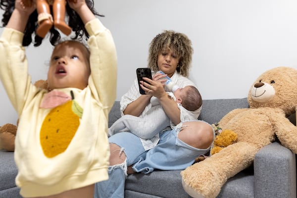 Lauren Chambers feeds her son Hayden, six months, as her daughter Lola, 2, plays at their home in Smyrna on Monday, May 5, 2025. (Arvin Temkar/AJC)