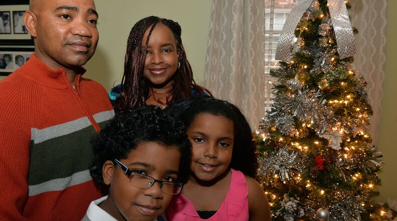 Damion Roman, a sergeant in the Georgia Army National Guard, is home in time for Christmas. His deployment ended early. He rejoined his family on Tuesday at a ceremony in Toccoa. Now, back home, he was in the kitchen on this Christmas Eve, doing something dad has traditionally done: He’ll be making dumplings. He’s shown with his wife, Stacey, and their 9-year-old twins, Nathaniel and Anaya in their Stone Mountain home. KENT D. JOHNSON / KDJOHNSON@AJC.COM