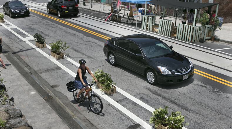 A woman rides her bike on the the safe bikes lanes created by plants in Atlanta on June 22, 2014.