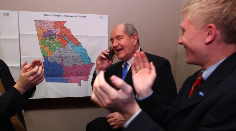 021105. ATLANTA. Sonny Perdue cq, Republican candidate for Governor, accepts congratulations on the phone from President Bush. Interestingly, the President's call to Perdue came before Barnes' call. This is taken in Perdue's war room. Right is campaign aide Nick Ayers cq. RICH ADDICKS/STAFF