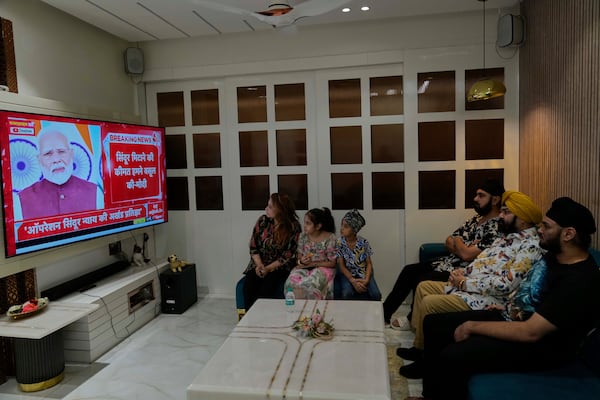 Family members watch the live telecast of Indian Prime Minister Narendra Modi's speech on a television at their residence in Hyderabad, India, Monday, May 12, 2025. (AP Photo/Mahesh Kumar A.)