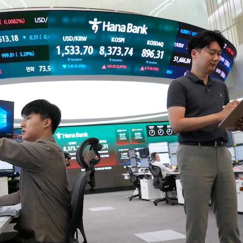 Currency traders work near a screen showing the Korea Composite Stock Price Index (KOSPI) and the foreign exchange rate between U.S. dollar and South Korean won at the foreign exchange dealing room of the Hana Bank headquarters in Seoul, South Korea, Wednesday, June 24, 2026. (AP Photo/Ahn Young-joon)