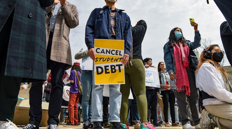 Activists rally outside the Department of Education in Washington on April 4, 2022, to call for student loan forgiveness. President Joe Biden faces heavy pressure from borrowers and progressive Democrats to reform the $1.6 trillion federal student loan system. In late July, students representing 11 colleges in Georgia traveled to Washington to rally at the White House. (Kenny Holston/The New York Times)
