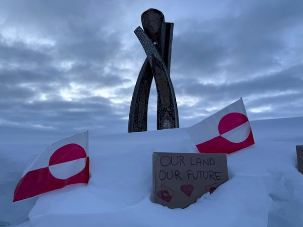 Two Greenland flags and a sign that reads "Our land, Our future" are seen in front of the Inussuk statue, a sculpture marking the start of Self Governance, during a visit by US Vice President JD Vance in Nuuk Greenland, Friday, March 28, 2025. (AP Photo/ Philip Crowther)