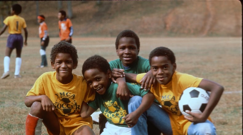 Four boys from a 1980s YMCA soccer team pose for a photo. (Courtesy of YMCA of Metro Atlanta)