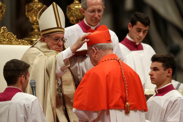 FILE - New Cardinal Kevin Joseph Farrell, prefect of the Vatican dicastery for laity, family and life, receives the red three-cornered biretta hat from Pope Francis inside St. Peter's Basilica at the Vatican on Nov. 19, 2016. (AP Photo/Gregorio Borgia, File)