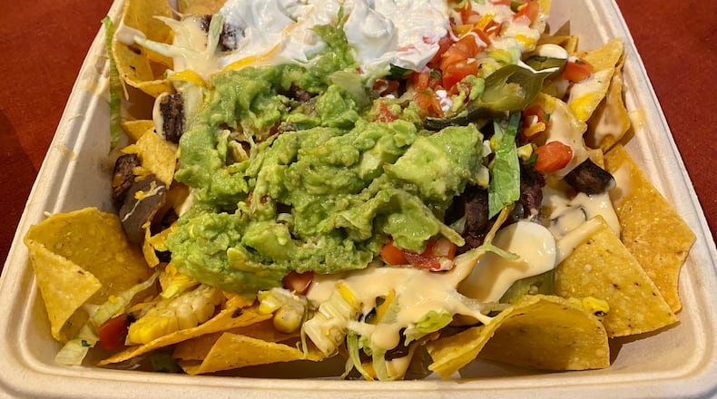 Nachos Botica is one of a handful of appetizers on the menu of newly opened bodega Botica. Nachos toppings include refried beans, tomatoes, shredded lettuce, corn, warmed queso, guacamole and crema. Orders can include proteins like chicken, shrimp or steak for an upcharge.
Ligaya Figueras / ligaya.figueras@ajc.com