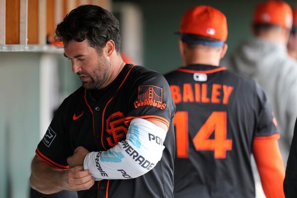 San Francisco Giants starting pitcher Robbie Ray wraps his pitching arm in the dugout during the fourth inning of a spring training baseball game against the Texas Rangers, Thursday, March 13, 2025, in Scottsdale, Ariz. (AP Photo/Ross D. Franklin)