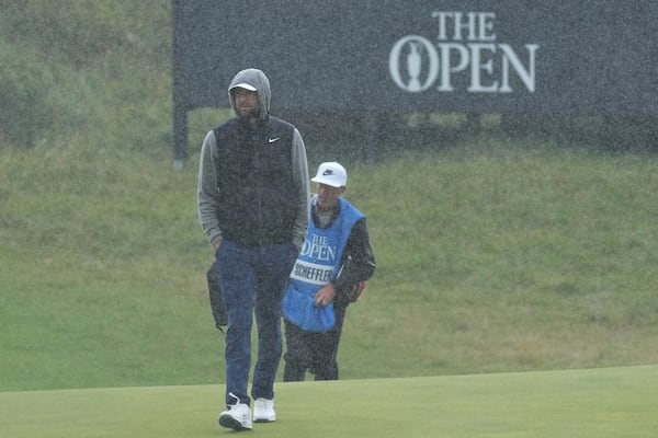 Scottie Scheffler of the United States walks onto the 8th green in heavy rain during a practice round for the British Open golf championship at the Royal Portrush Golf Club, Northern Ireland, Tuesday, July 15, 2025. (AP Photo/Jon Super)