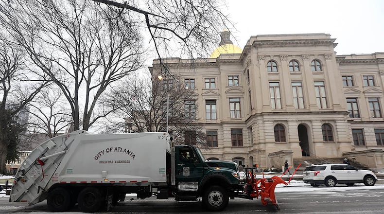 An Atlanta city garbage truck with a snow plow attached makes its way up Washington Street by the Georgia Capitol on Wednesday morning February 12, 2014 as an ice storm moves through the Metro.
