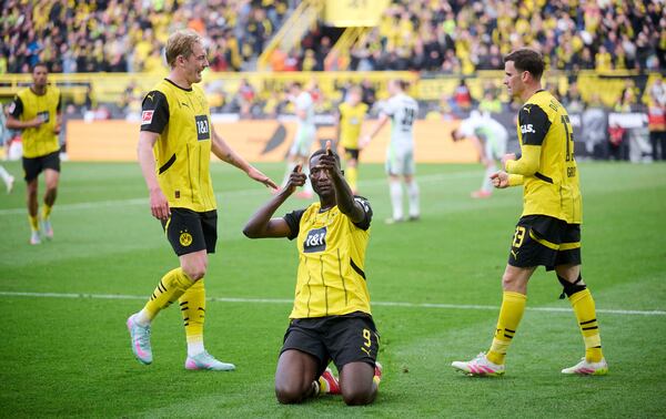 Dortmund's Serhou Guirassy, center, celebrates his goal with Julian Brandt, left and Pascal Groß, during the German Bundesliga soccer match between Borussia Dortmund and VfL Wolfsburg, at Signal Iduna Park, in Dortmund, Germany, Saturday, May 3, 2025. (Bernd Thissen/dpa via AP)