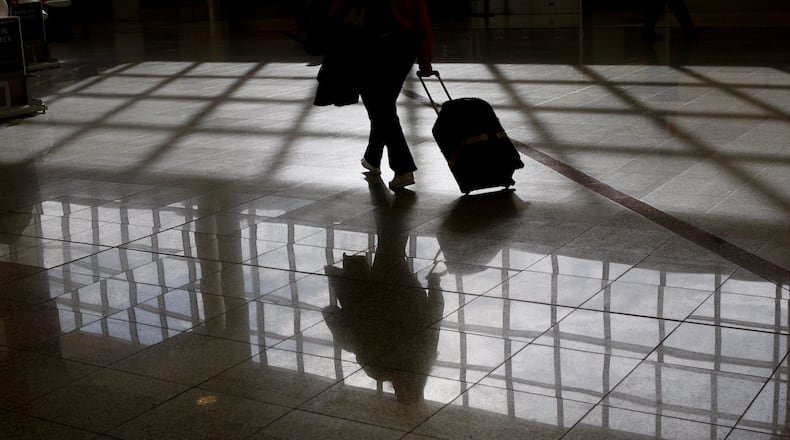 A traveler heads for the Delta ticket counter with a bag at Hartsfield-Jackson International. A longstanding lawsuit over baggage fees claims that Delta and AirTran colluded to establish the fees. John Spink, jspink@ajc.com