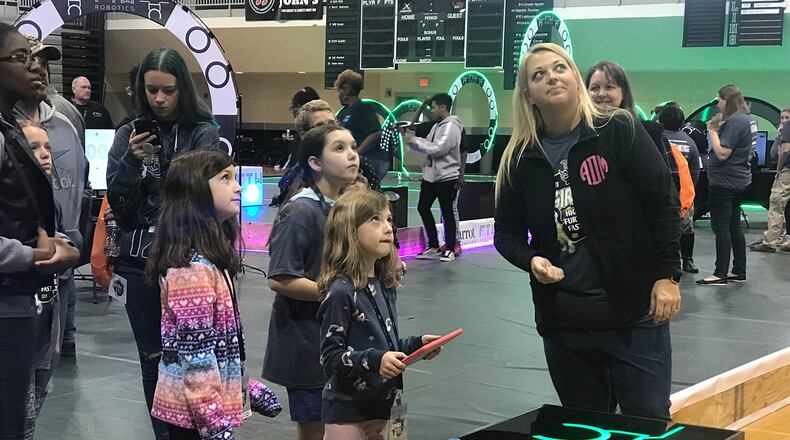 Fly Girls instructor Alana Davis (right) leads members of the STEM club through an exercise to launch and land a drone.