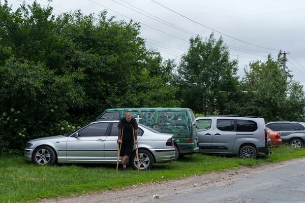 A former Ukrainian soldier with an amputated limb participates the funeral ceremony for his comrade Dmytro Shapovalov in Yosypivka village, Vinnytsia region, Ukraine, on Friday, June 13, 2025. (AP Photo/Evgeniy Maloletka)