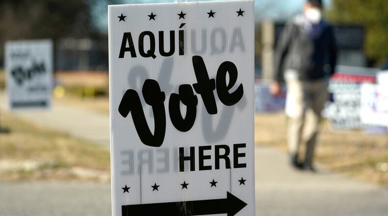 FILE - A man passes an early voting poll site, Feb. 14, 2022, in San Antonio. (AP Photo/Eric Gay, File)