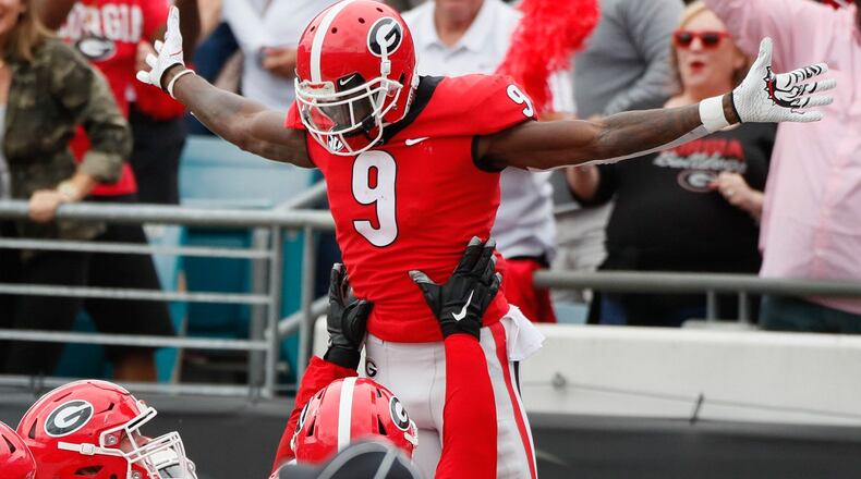 Georgia wide receiver Jeremiah Holloman is lifted by teammates after scoring the Bulldogs' first TD on Saturday, Oct. 27, 2018, at TIAA Bank Field in Jacksonville, Fla. BOB ANDRES / BANDRES@AJC.COM