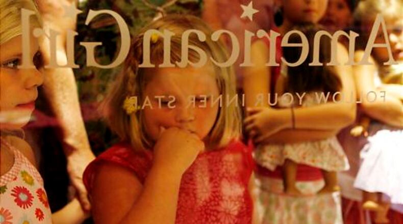 Grace Sorgeloos, 7, and her sister, Kylie, 5, wait at the front of the line at The American Girl Boutique and Bistro at North Point Mall in Alpharetta on Friday night. The two were looking to buy as much as they can during the store's benefit supporting Children's Healthcare of Atlanta.