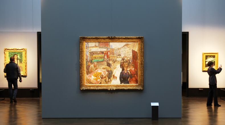 Journalists walks next to the painting "Place Clichy" from 1867-1947 by Pierre Bonnard during the press preview for the exhibition "The Scharf Collection: Goya – Monet – Cezanne – Bonnard – Grosse" at the Alte Nationalgalerie museum in Berlin, Wednesday, Oct. 22, 2025. (AP Photo/Maryam Majd)