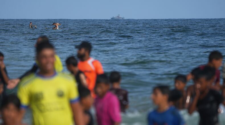 An Israeli navy vessel patrols off the Mediterranean coast as Palestinian children participate in the "Swimming with Gaza" event in Khan Younis, southern Gaza Strip, Friday, Aug. 21, 2026. (AP Photo/Abdel Kareem Hana)