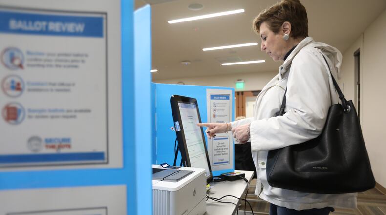 Andrea Settles practices completing a ballot on one of Fulton County’s new voting machines during a mock election held at Sandy Springs Library in February.