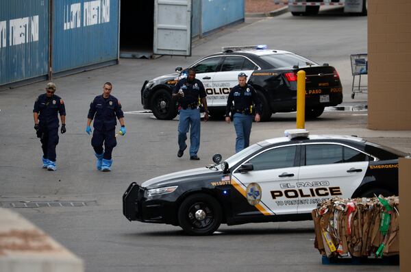 FILE - In this Aug. 6, 2019, file photo, police officers walk behind a Walmart at the scene of a mass shooting at a shopping complex in El Paso, Texas. (AP Photo/John Locher, File)