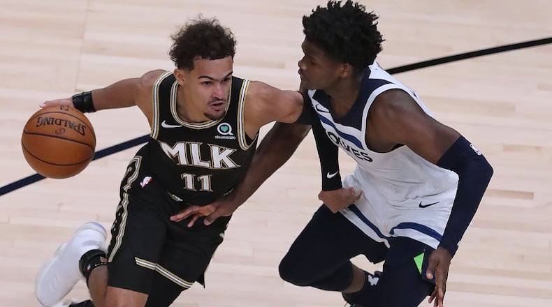 Hawks guard Tray Young drives against Minnesota Timberwolves guard Anthony Edwards in the MLK Day Unity game Monday, Jan. 18, 2021, at State Farm in Atlanta. Edwards, a former Georgia Bulldog and first-overall draft pick, was playing his first NBA game back in his hometown. (Curtis Compton / Curtis.Compton@ajc.com)