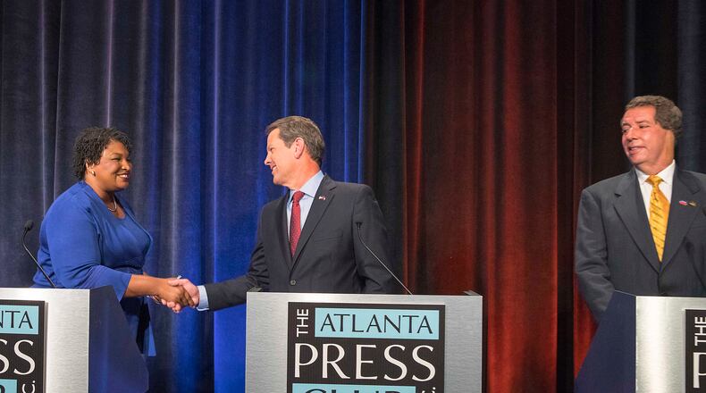 Libertarian candidate Ted Metz (far right) watches as Democratic candidate Stacey Abrams and Republican candidate Brian Kemp greet each other before a gubernatorial debate sponsored by the Atlanta Press Club at the Georgia Public Broadcasting studio in Atlanta on Oct. 23, 2018. ALYSSA POINTER/ALYSSA.POINTER@AJC.COM