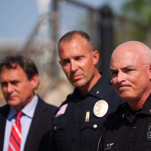 Burnsville Police Chief Matt Smith, right, attends a news conference in Hopkins, Minn., Wednesday, Aug. 12, 2026, where police said a man who killed his wife and their 7-year-old daughter at an in-home daycare is also suspected of killing a 78-year-old female relative. (AP Photo/Ellen Schmidt)