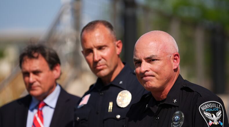 Burnsville Police Chief Matt Smith, right, attends a news conference in Hopkins, Minn., Wednesday, Aug. 12, 2026, where police said a man who killed his wife and their 7-year-old daughter at an in-home daycare is also suspected of killing a 78-year-old female relative. (AP Photo/Ellen Schmidt)