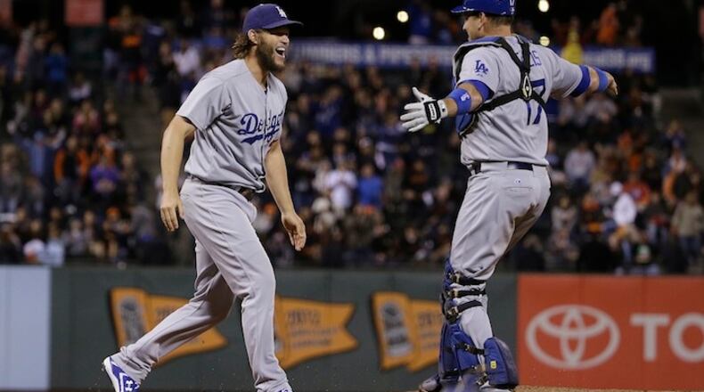 Los Angeles Dodgers pitcher Clayton Kershaw, left, celebrates with catcher A.J. Ellis (17) after beating the San Francisco Giants in a baseball game in San Francisco, Tuesday, Sept. 29, 2015. The Dodgers won 8-0 to clinch the National League West division. (AP Photo/Jeff Chiu)