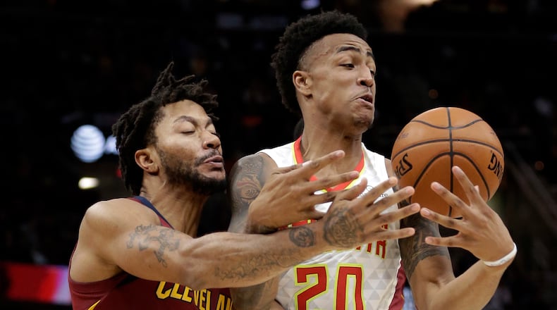 Atlanta Hawks' John Collins (20) and Cleveland Cavaliers' Derrick Rose (1) battle for the ball in the first half of an NBA basketball game Sunday, Nov. 5, 2017, in Cleveland. (AP Photo/Tony Dejak)