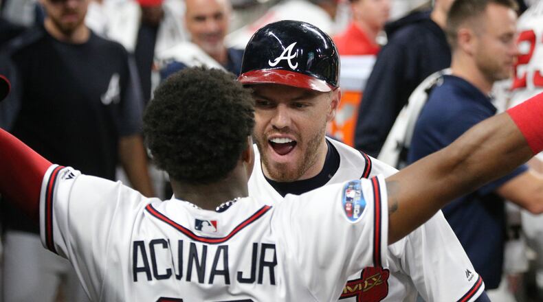 Braves first baseman Freddie Freeman celebrates his solo home run with left fielder Ronald Acuna in Game 3 of the National League Division Series Sunday, Oct. 7, 2018, in Atlanta.
