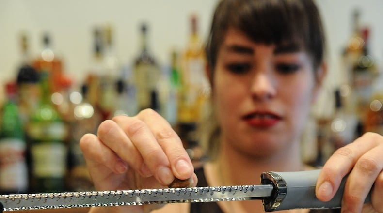 Bar Manager Shanna Mayo finishes the Smoke & Chill cocktail with mezcal, pineapple, banana, cinnamon, lime, Angostura bitters, nutmeg and mint at Amer in Inman Park. (Beckysteinphotography.com)