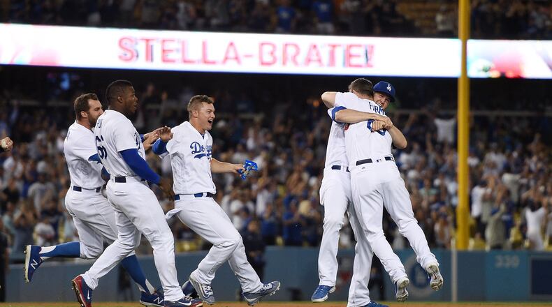 Kyle Farmer of the Los Angeles Dodgers is congratulated by teammates after hitting a game-winning double in his first MLB at-bat against the San Francisco Giants in the 11th inning at Dodger Stadium on July 30, 2017, in Los Angeles, California. (Photo by Kevork Djansezian/Getty Images)