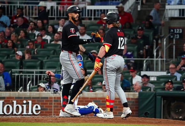 Minnesota Twins shortstop Carlos Correa (4) celebrates his solo homerun at the plate with Minnesota Twins outfielder Harrison Bader (12) against the Atlanta Braves during the fourth inning in a baseball game at Truist Park, Saturday, April 19, 2025, in Atlanta. (AP Photo/ John David Mercer)
